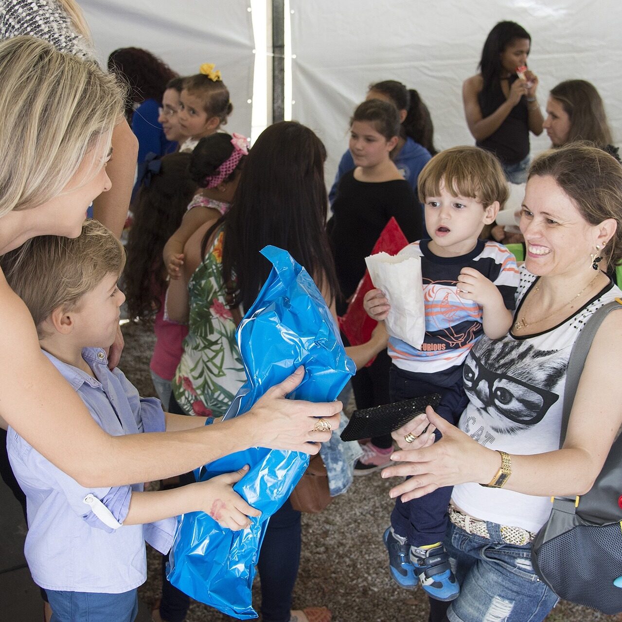 Group of people - mother young boy giving to another mother and son